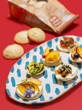 Load image into Gallery viewer, Bread SRSLY gluten-free dinner rolls on a serving platter with various gluten-free toppings.