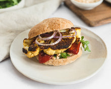 Load image into Gallery viewer, A vegetarian cauliflower &quot;steak&quot; sandwich with red pepper, arugula and red onion on a Bread SRSLY gluten-free sourdough Sandwich roll