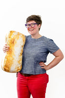 CEO and Founder, Sadie Scheffer, holding a large bread pillow
