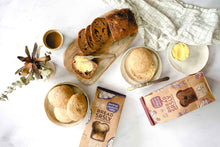 Load image into Gallery viewer, Bread SRSLY Gluten-Free Sourdough Sandwich Rolls and Cinnamon Raisin Sourdough Bread packaging, sliced loaf, and roll on table  with butter and coffee