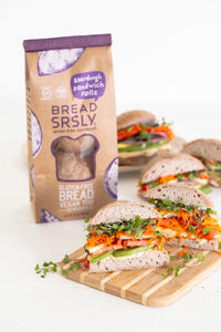 Bread SRSLY gluten-free sourdough Sandwich rolls in packaging on the left. Sandwich rolls sliced in half as veggie packed sandwiches, cut crosswise to show filling.
